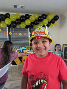 Yellow and black balloon garland with caution banners at a construction-themed birthday party.