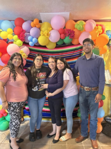 Multicolor organic balloon garland with paper flowers framing a striped serape backdrop for Mother's Day.