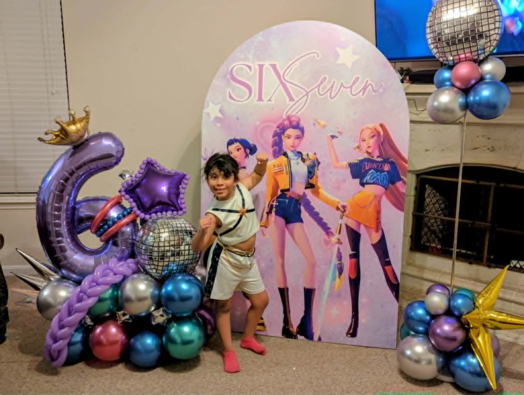 Bold layered balloon installation with a custom backdrop, designed and installed by Emerald Balloon Designs in the Houston area