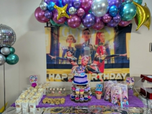 Chrome purple, blue, pink, and gold organic garland with star foils above a birthday dessert table.