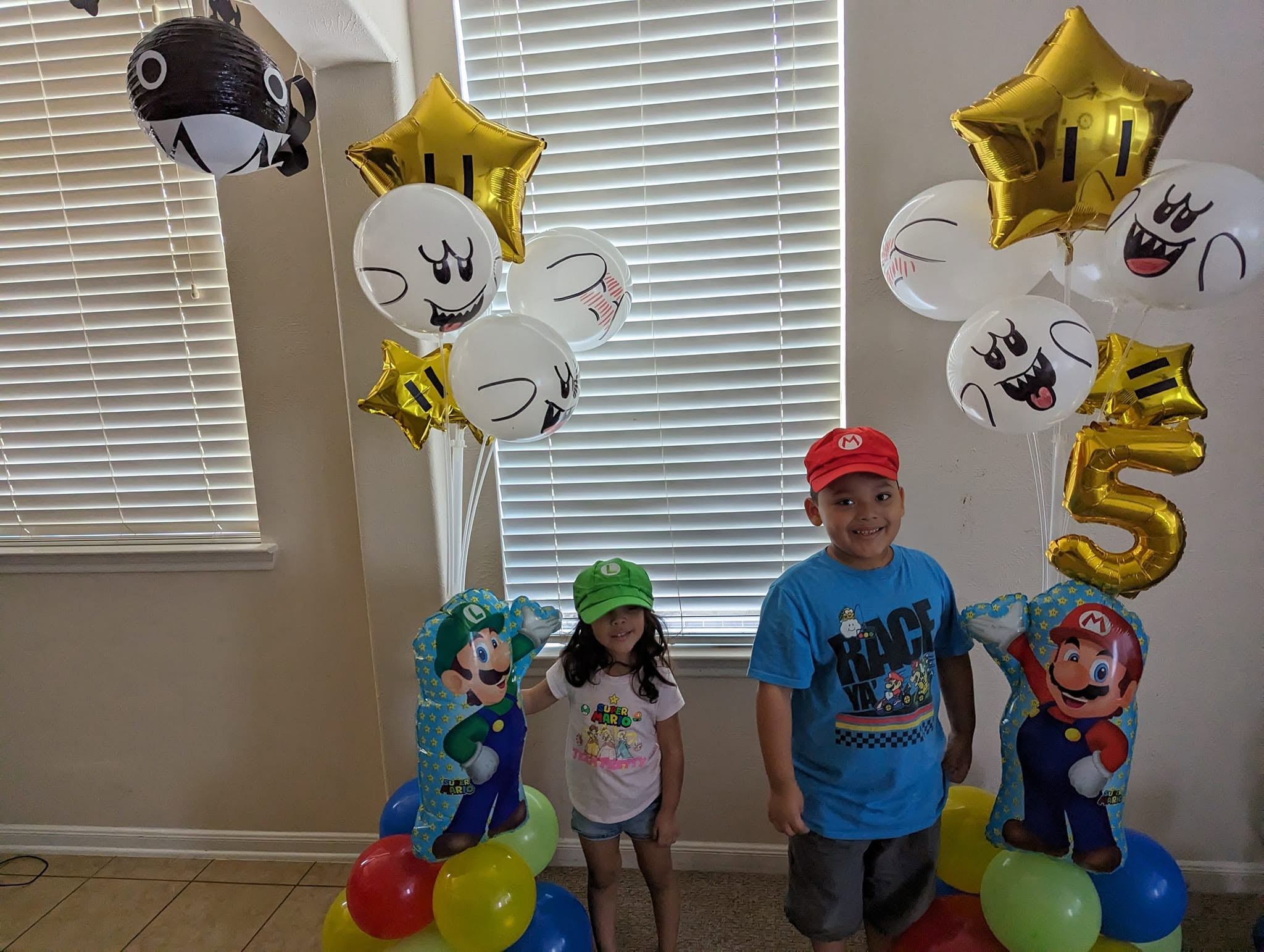 Two floating balloon columns in primary colors with star foils for a fifth birthday.
