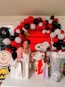 Red, black, and white organic balloon garland arcing over a themed backdrop at an indoor party.