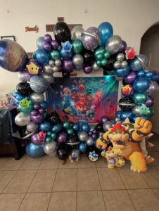 Full chrome balloon ring in purple, teal, and silver surrounding a themed fabric backdrop.